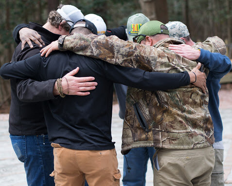 Veterans huddled together in a circle.