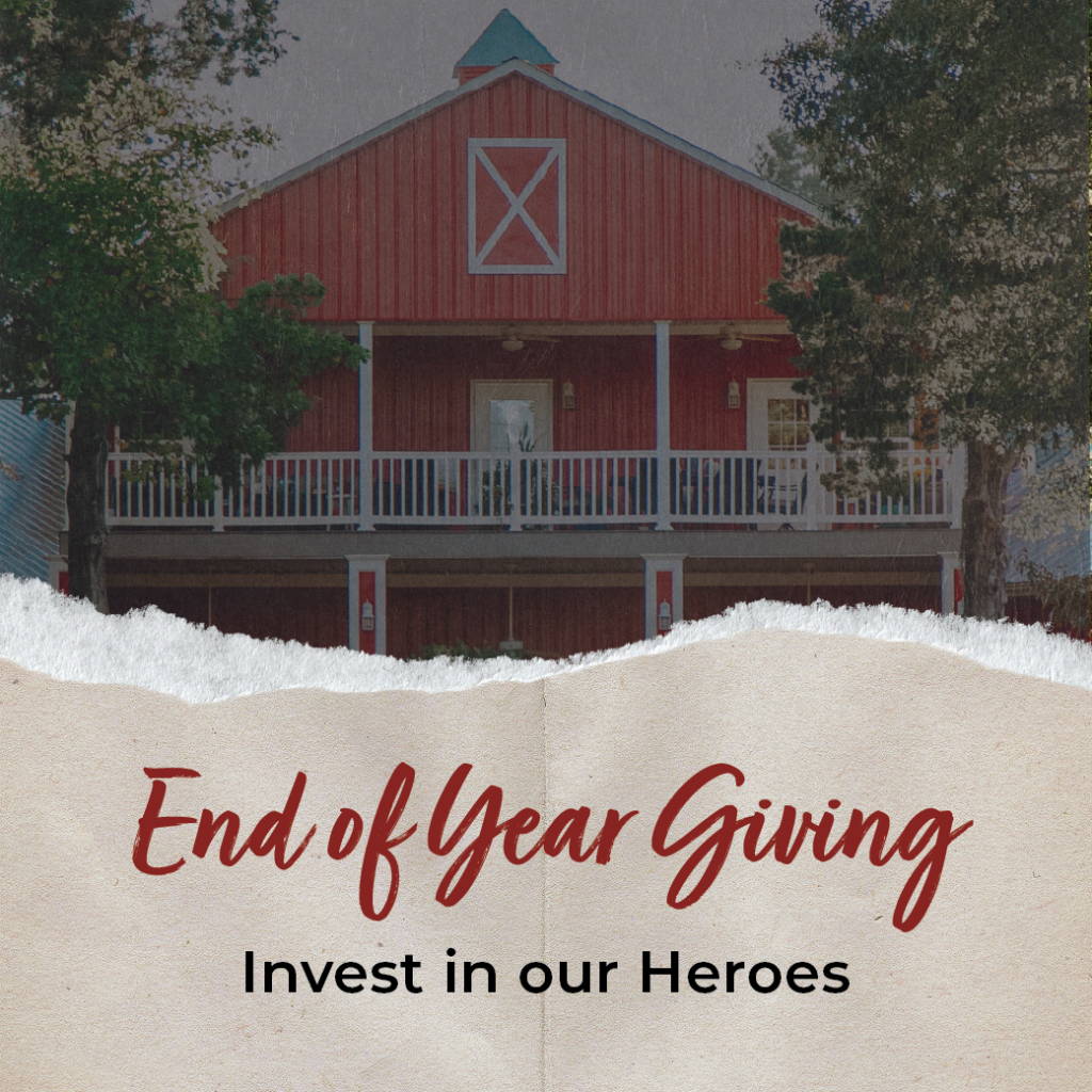 A red barn-style building with End of Year Giving—Invest in our Heroes written in front.